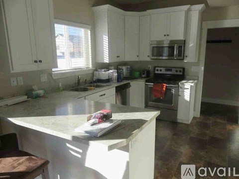 A kitchen with white cabinets and a granite countertop.