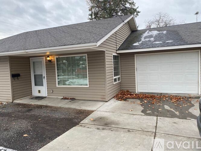 A house with a white door and a garage door is available for rent.