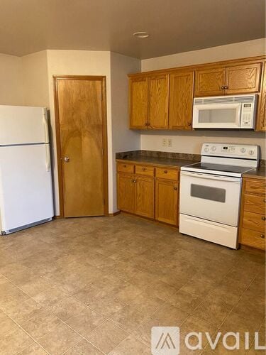 A kitchen with a white fridge, white microwave, and white oven.
