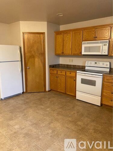 A kitchen with a white fridge, white microwave, and white oven.