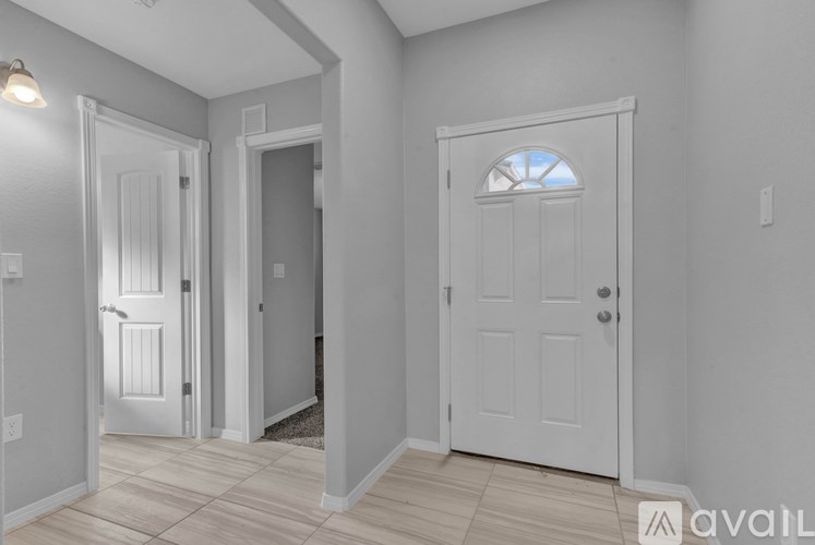 A hallway with two doors and a window.