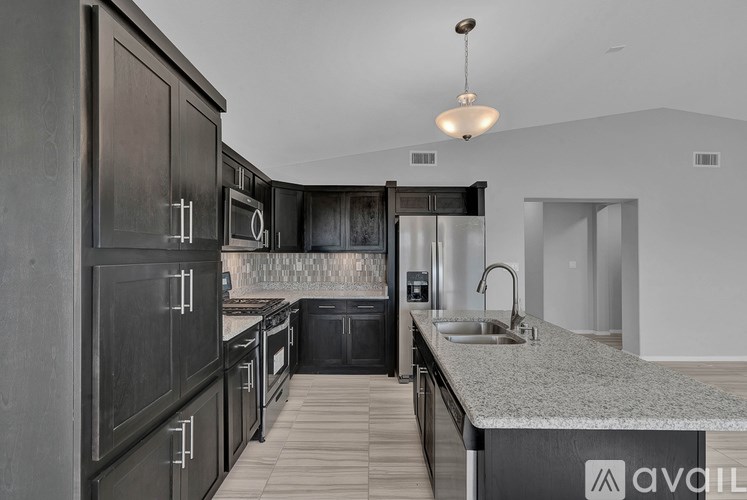 A modern kitchen with dark wood cabinets and a granite countertop.