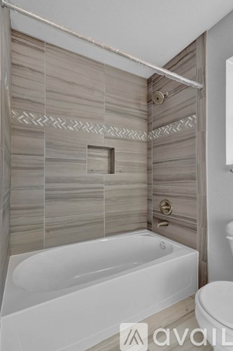 A bathroom with a white bathtub and a toilet.