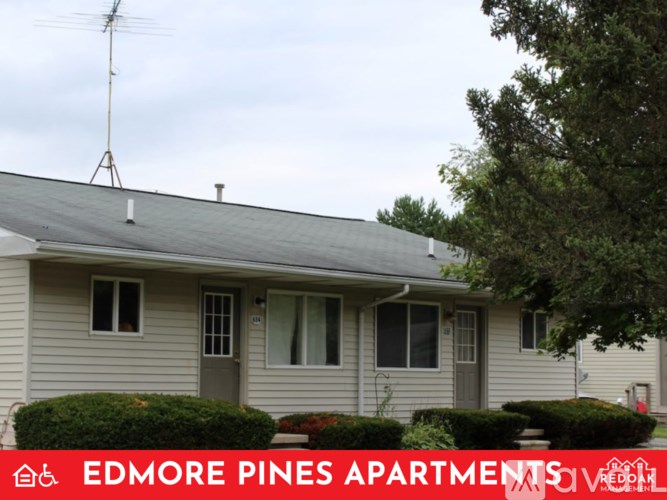 A house with a grey roof and a sign that says Edmore Pines Apartments.