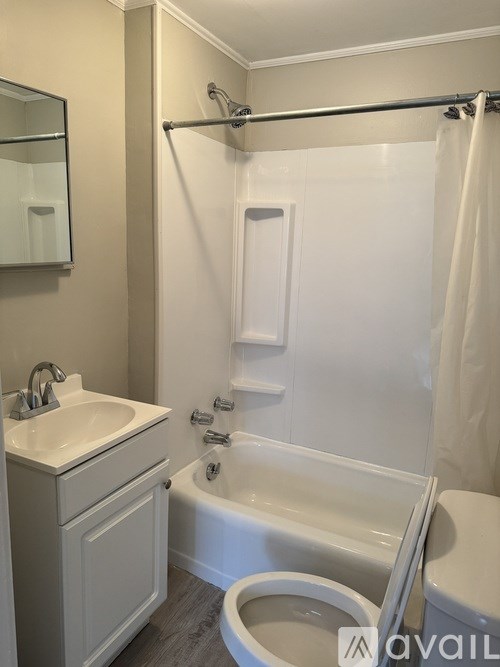 A white bathroom with a toilet, sink, and bathtub.