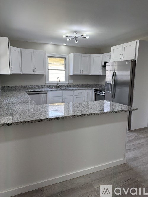 A kitchen with granite countertops and white cabinets.