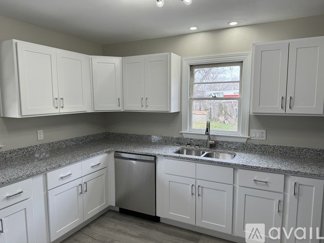 A kitchen with white cabinets and a granite countertop.