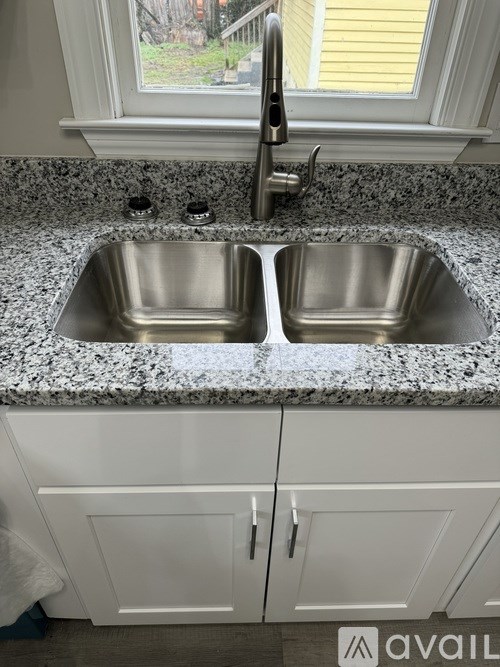 A kitchen with a granite countertop and a double sink.