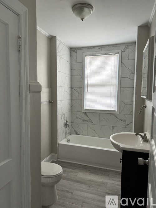 A bathroom with a toilet, sink, and bathtub.