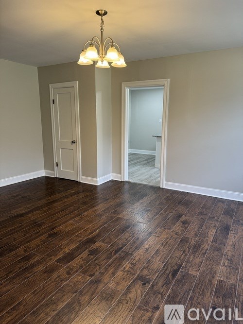 A room with wooden floors and a chandelier.