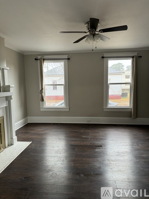 A room with a fireplace and a ceiling fan.