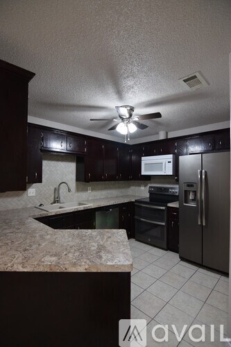 A kitchen with a granite counter top and stainless steel appliances.
