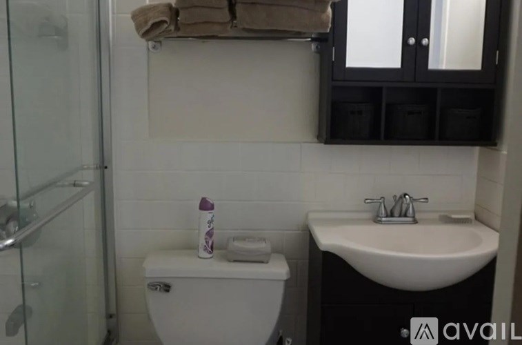 A white toilet sits next to a white sink in a bathroom.