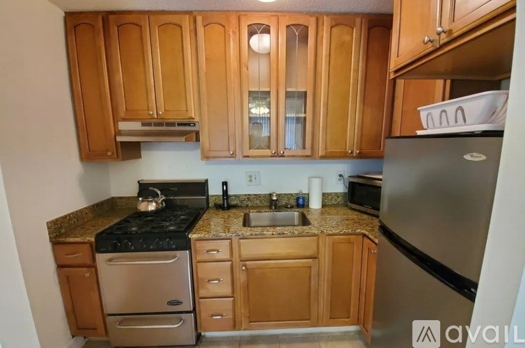 A kitchen with wooden cabinets and a granite countertop.