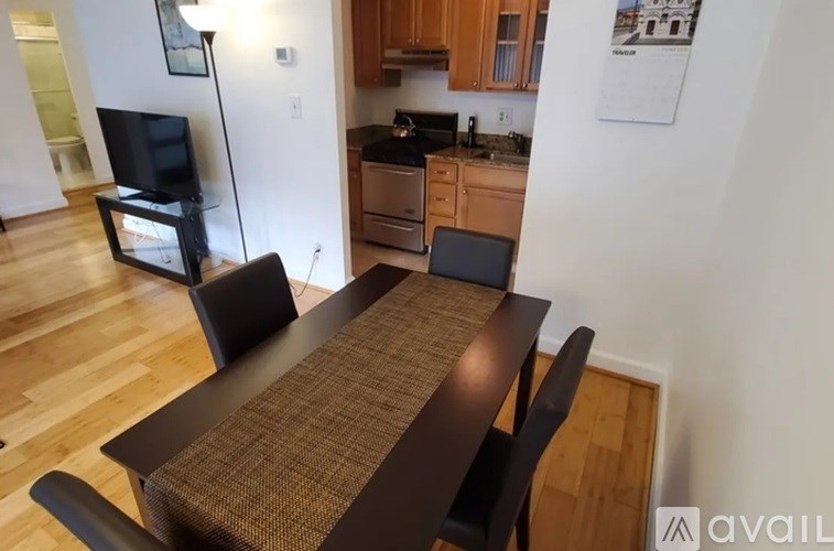 A kitchen with a table and chairs in the foreground.
