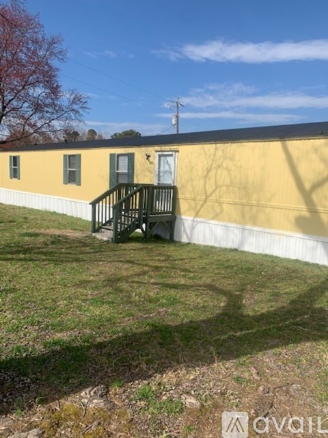 A yellow building with a green door and a black railing.