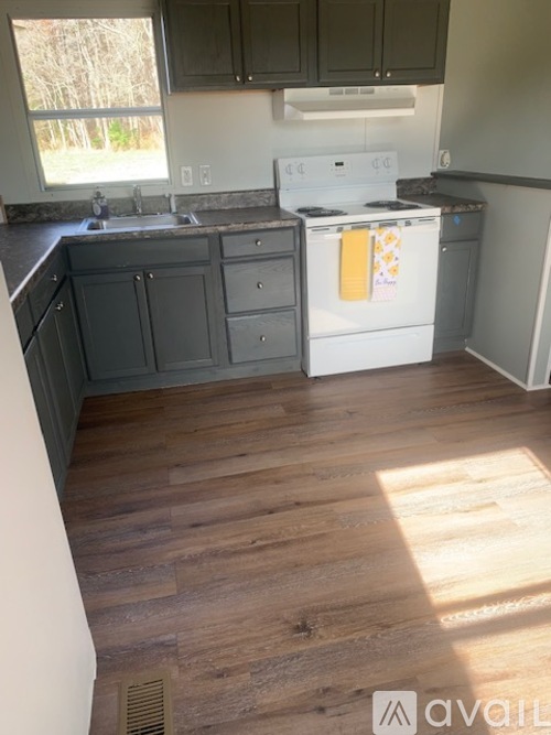A kitchen with a white stove top oven and a white dishwasher.
