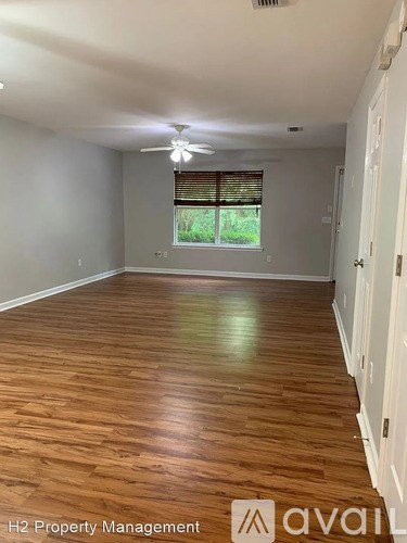 A room with wooden flooring and a ceiling fan.