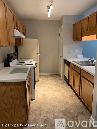 A kitchen with wooden cabinets and a white countertop.