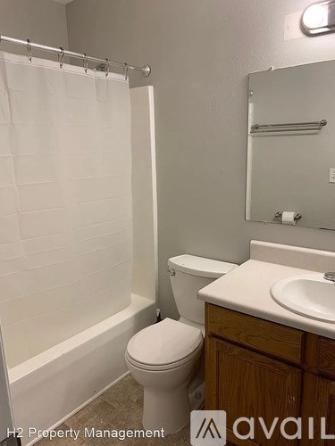 A white toilet sits next to a sink in a small bathroom.