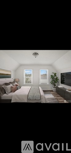 A bedroom with a bed, nightstand, and a window with a view of the sky.