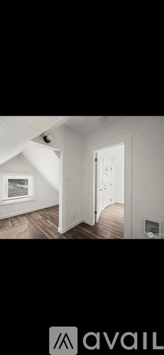 A room with a window and wooden flooring.
