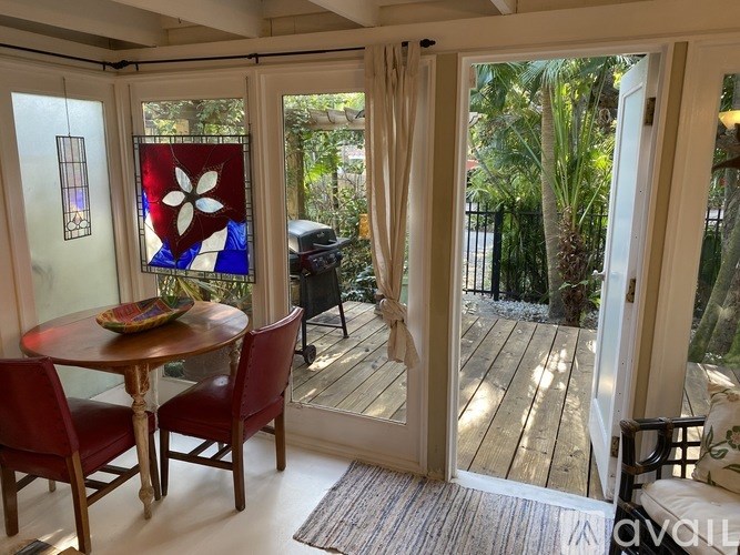 A table with chairs and a stained glass window in a room.