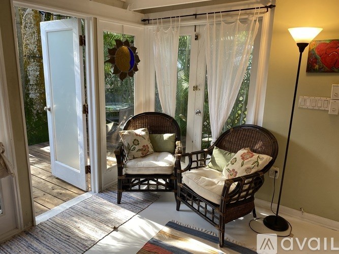 A patio with two chairs and a table with a lamp.