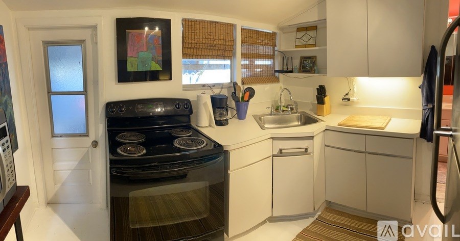 A modern kitchen with a stove, sink, and cabinets.