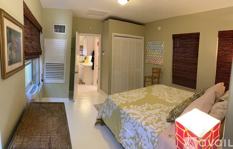 A bedroom with a bed, a chair, and a painting on the wall.