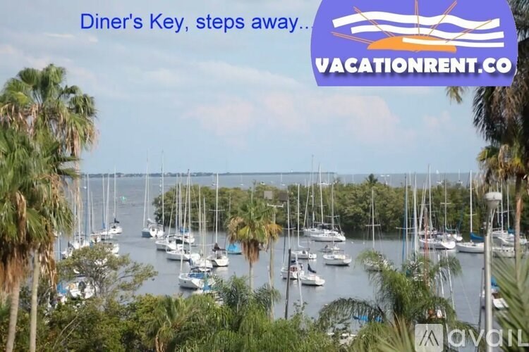 A scenic view of a marina with boats docked in the water and palm trees in the foreground.