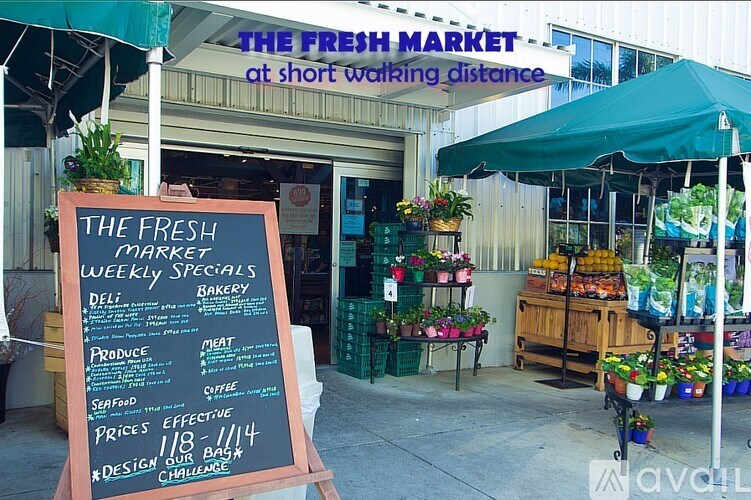 A signboard outside a fresh market with a variety of vegetables on display.