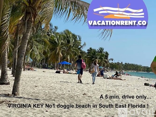 A beach scene with people walking and relaxing on the sand.