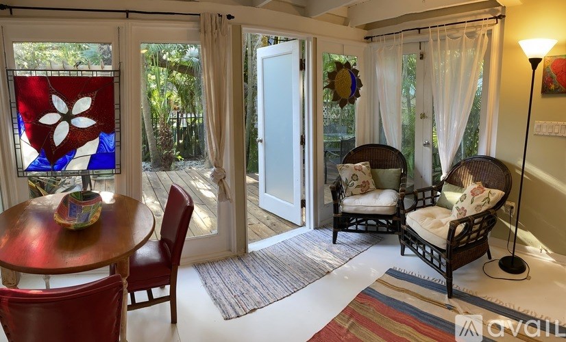 A room with a table, chairs and a door.