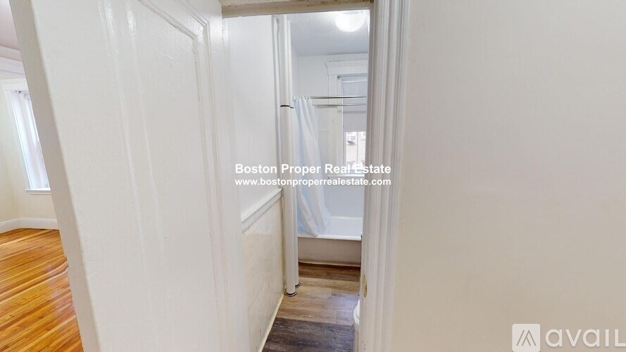 A hallway with a door on the left and a window on the right.