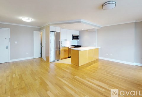 A kitchen area with wooden flooring and a refrigerator.