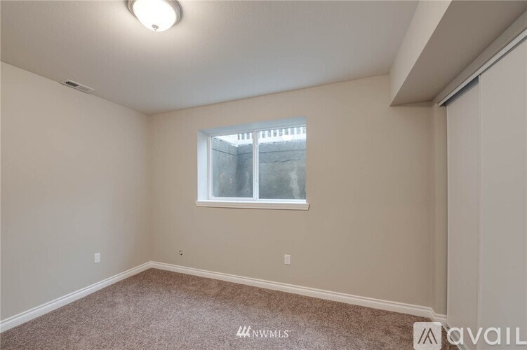 A room with a window and carpeted floor.