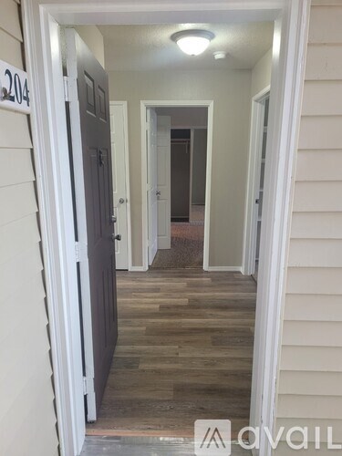 A hallway with a door on the left and a door on the right.