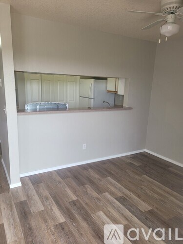A room with wooden flooring and a ceiling fan.