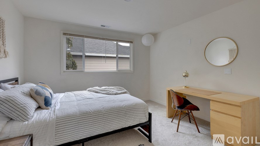 A bedroom with a bed, desk, and chair.