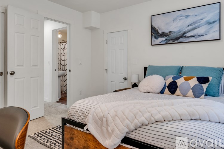 A bedroom with a large bed and a painting on the wall.