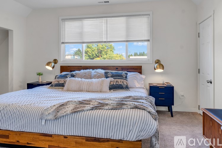 A bedroom with a large bed and two lamps.