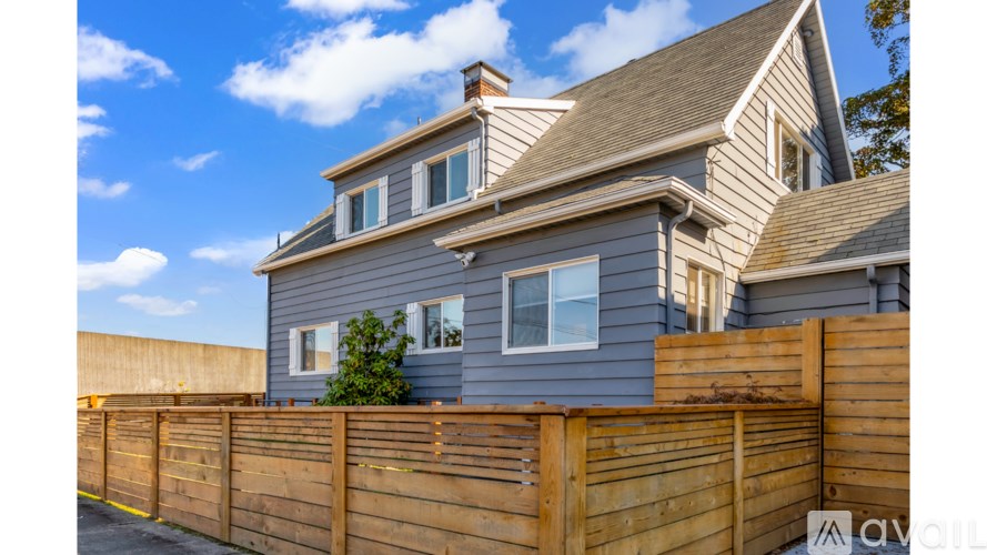 A house with a grey exterior and a wooden fence.