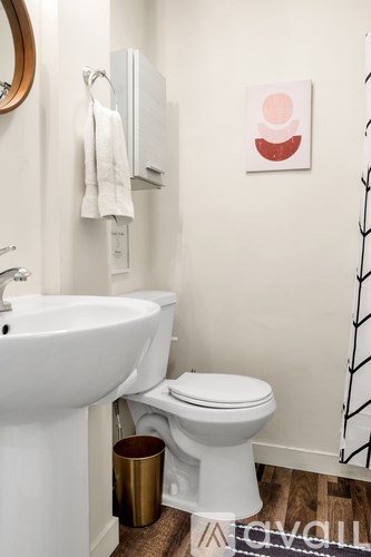 A white toilet sits next to a white sink in a small bathroom.