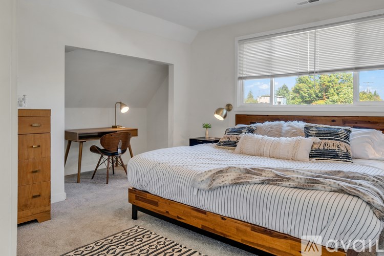 A bedroom with a bed, desk, and chair.