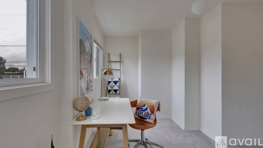 A room with a white table and a chair with a pillow that says "EXPLORE".