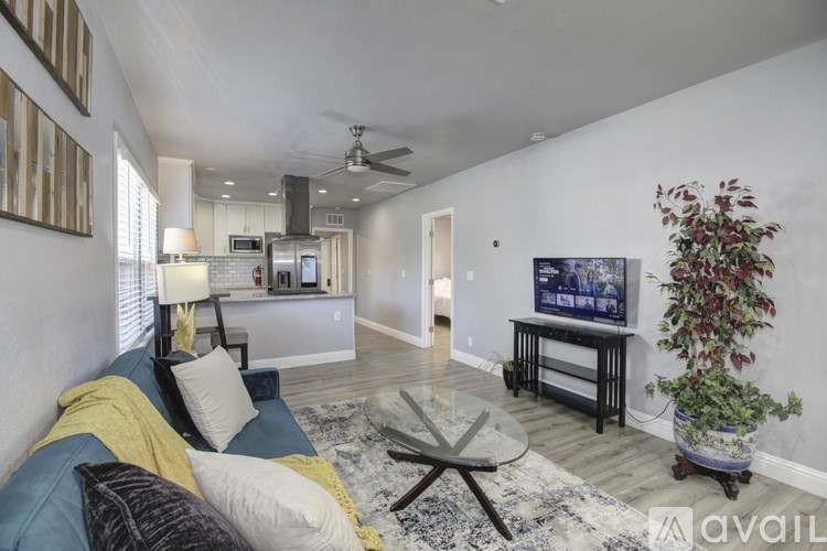 A living room with a blue couch and a television on a stand.