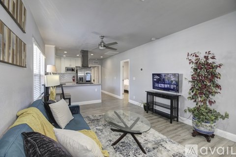 A living room with a blue couch and a television on a stand.