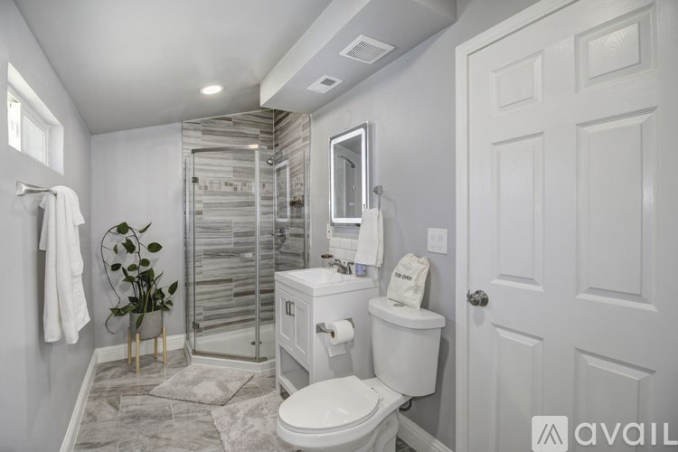 A bathroom with a toilet, sink, and shower.