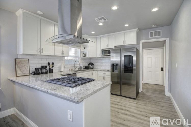 A kitchen with a marble countertop and stainless steel appliances.